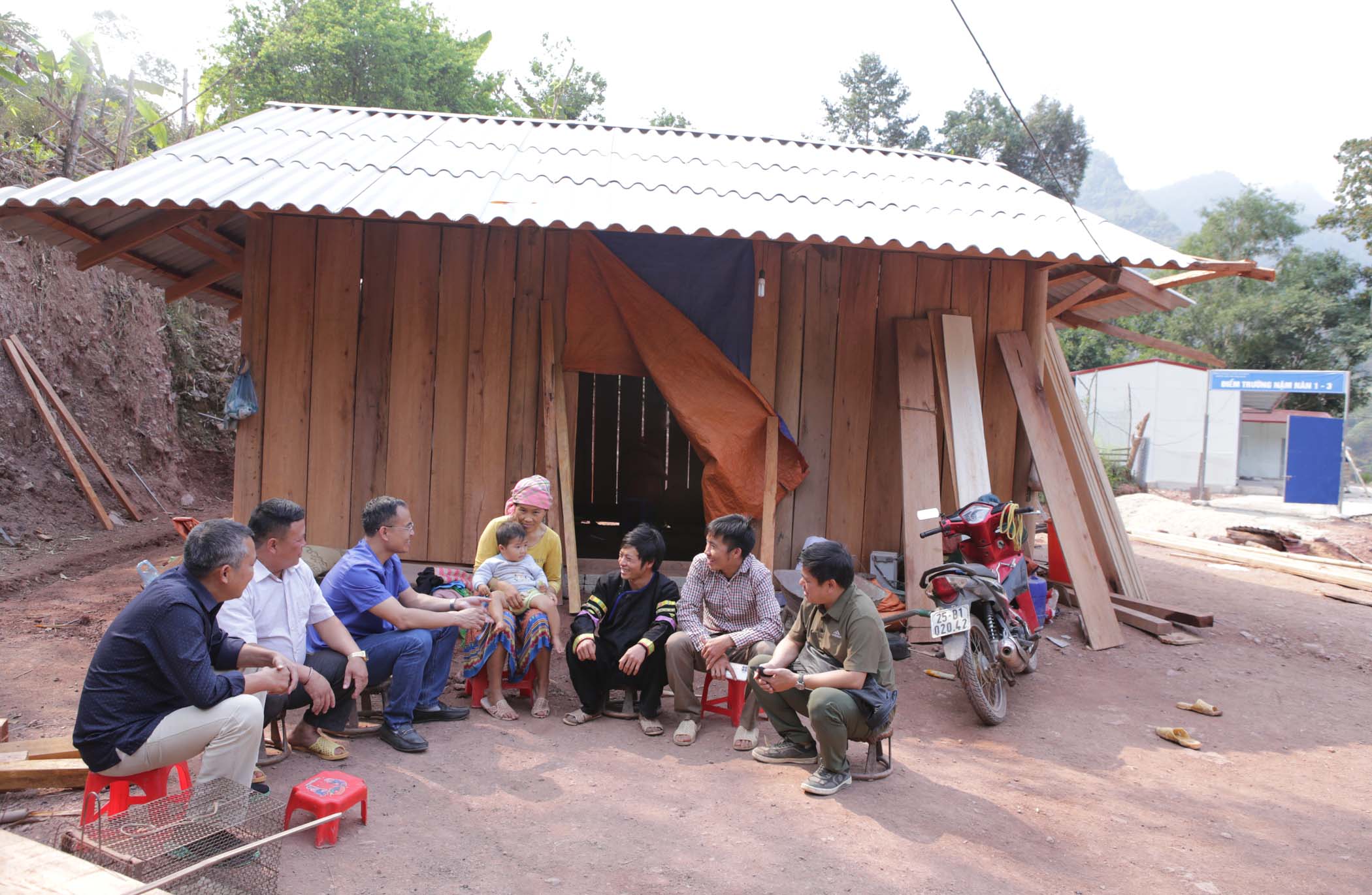 Anh Mùa A Ký (thứ 2 từ bên phải) trò chuyện với lãnh đạo địa phương.